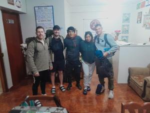 a group of people posing for a picture in a room at Yerupaja Mountain Hostel in Huaraz
