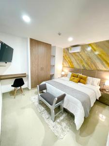 um quarto com uma cama grande e uma televisão em Hotel Olam Deluxe Valledupar em Valledupar
