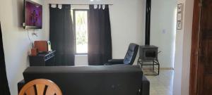 uma sala de estar com um sofá e uma televisão em casa la infancia em Perito Moreno