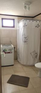 a bathroom with a shower curtain and a toilet at casa la infancia in Perito Moreno