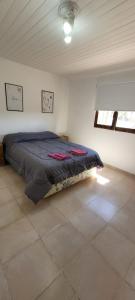 1 dormitorio con 1 cama en una habitación blanca en casa la infancia en Perito Moreno