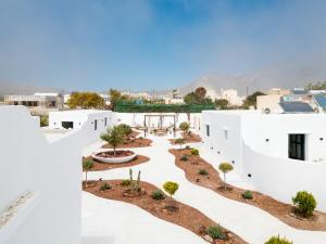 vistas al patio de un edificio blanco con árboles en Electra Suites & Spa en Perivolos