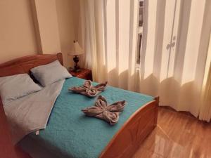 Un dormitorio con una cama con dos flores. en HOSPEDAJE VALERY, en Trujillo