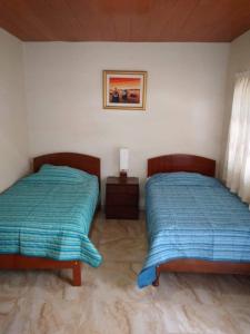 dos camas sentadas una al lado de la otra en un dormitorio en HOSPEDAJE VALERY, en Trujillo