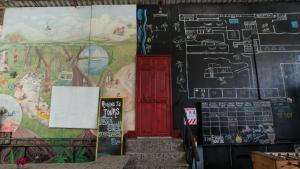 una habitación con una pintura en la pared y una puerta roja en Rocking J's, en Puerto Viejo