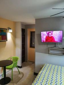 Una habitación con una cama y un televisor en la pared. en R.503 Lindo y funcional apartaestudio en el centro, en Panamá