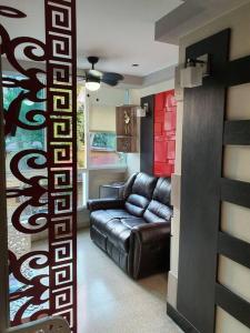 a living room with a leather couch in a room at R.503 Lindo y funcional apartaestudio en el centro in Panama City