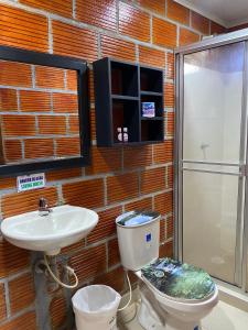 een badkamer met een toilet en een wastafel bij ECORAUDAL posada campestre in San José del Guaviare