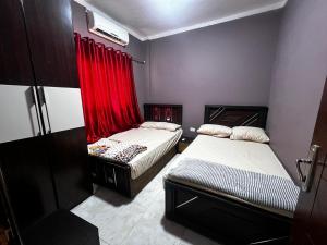 ラス・スダーにあるCozy Villla In Ras Sidrの赤いカーテン付きの部屋のベッド2台