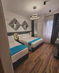 a hotel room with two beds and a television at Klaudia Apartments in Himare