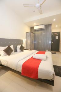 um quarto com uma cama grande e um cobertor vermelho e branco em Hotel Leesha Residency em Kalyan