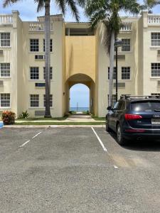 samochód zaparkowany na parkingu przed budynkiem w obiekcie Beachfront Bliss w mieście Rincón