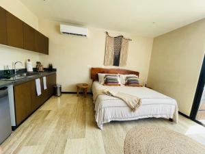 a small bedroom with a bed and a kitchen at Casa del Sol in Tulum