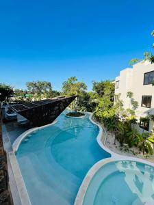 a swimming pool in a resort with a building at Casa del Sol in Tulum