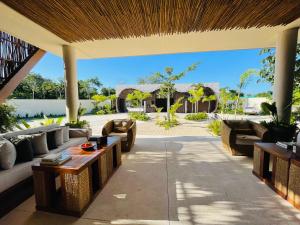 an outdoor patio with couches and a table at Casa del Sol in Tulum