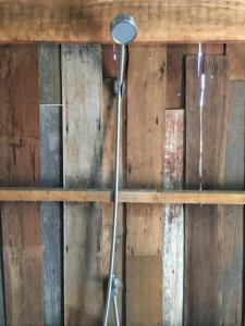 eine Dusche in einem Zimmer mit einer Holzwand in der Unterkunft สวนบ้านนอก SuanBaanNoak in Phayao