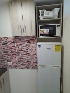 a microwave on top of a refrigerator in a kitchen at R.5-5 Lindo estudio, 2 recámaras en zona turística in Panama City