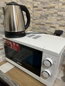 a microwave with a coffee pot on top of it at Apartment luxe Atilamonou in Lomé