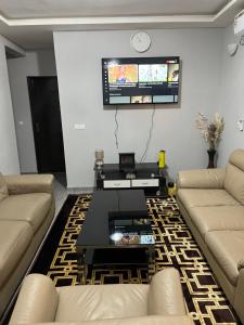 a living room with two couches and a tv at Apartment luxe Atilamonou in Lomé