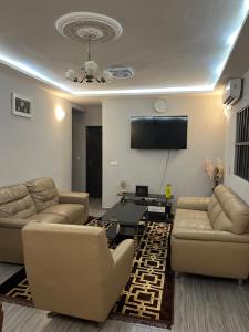 uma sala de estar com sofás e uma televisão de ecrã plano em Apartment luxe Atilamonou em Lomé