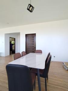 uma sala de jantar com uma mesa branca e cadeiras em TERESITA RESIDENCE em Manaoag