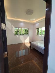 um quarto com uma cama e duas janelas em TERESITA RESIDENCE em Manaoag