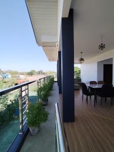 een kamer met een balkon met een tafel en stoelen bij TERESITA RESIDENCE in Manaoag