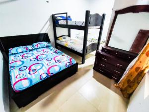 1 dormitorio con cama, tocador y espejo en Hotel Palmahia Moñitos, en Moñitos