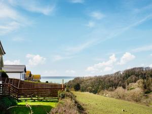 a house on a hill with the ocean in the background at Sea Breeze in Wembury