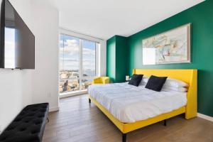a bedroom with a yellow bed with a green wall at Modern 3 BR 3.5 BA Breathtaking in Jersey City