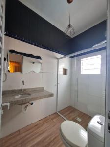 a bathroom with a toilet and a sink at Pousada Aconchego na Praia in Praia Grande