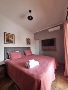 a bedroom with a red bed with a teddy bear on it at Pousada Aconchego na Praia in Praia Grande