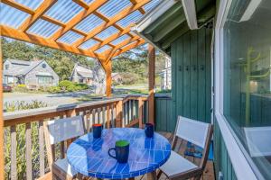 a table and chairs on a porch with a pergola at Odyssey in Cannon Beach