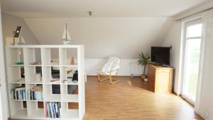 een woonkamer met een witte boekenplank bij Fewo Aron in Tönning