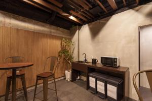 uma cozinha com um balcão, uma mesa e um micro-ondas em 3U NAMBA MINAMI by DOYANEN em Osaka