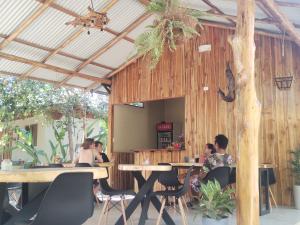a group of people sitting at tables in a restaurant at El Gecko Hotel & Tours in Paquera
