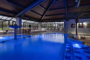 a large swimming pool with blue lighting in a building at Delta Hotels by Marriott Peterborough in Peterborough