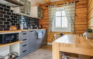 a kitchen with wooden walls and a wooden table at Beautiful Apartment In Sorkwity With House A Panoramic View in Sorkwity