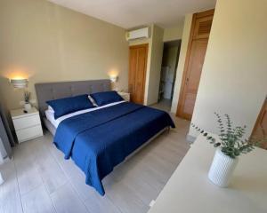 - une chambre avec un lit doté de draps bleus et d'un vase dans l'établissement Dominicus Royal Life, à La Laguna