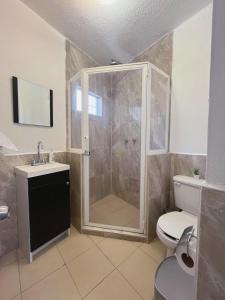 y baño con ducha, aseo y lavamanos. en Casa Geranio conveniente y funcional., en Cuernavaca