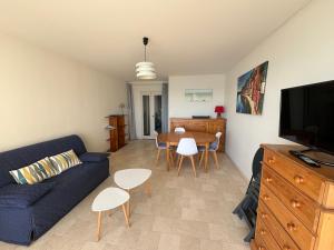 ein Wohnzimmer mit einem blauen Sofa und einem Tisch in der Unterkunft Appartement Les Sables-d'Olonne, 2 pièces, 4 personnes - FR-1-197-534 in Les Sables-dʼOlonne