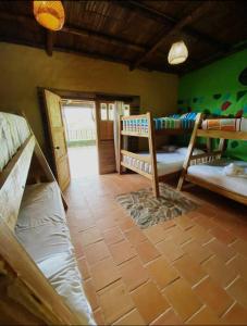 a room with several bunk beds in a room at Hostal El Santuario in Minca