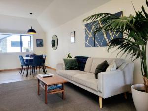 uma sala de estar com um sofá e uma mesa em Hagley Park Townhouse em Christchurch