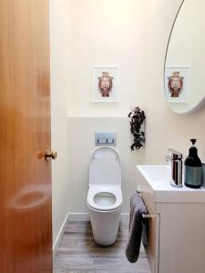 uma casa de banho branca com um WC e um lavatório em Hagley Park Townhouse em Christchurch