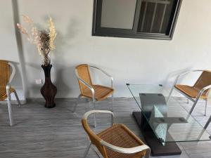 Pokój z krzesłami, stołem i wazą w obiekcie Apartment luxe Atilamonou w mieście Lomé