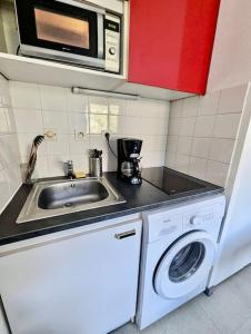 a kitchen with a sink and a washing machine at Pratique, Proche Gare & Petit Prix avec Parking in Grenoble