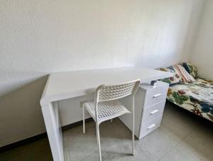 a white desk with a chair next to a bed at Pratique, Proche Gare & Petit Prix avec Parking in Grenoble