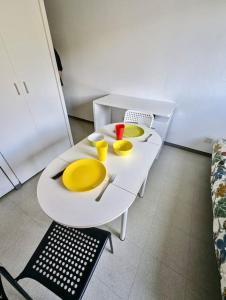 a white table with two yellow dishes on it at Pratique, Proche Gare & Petit Prix avec Parking in Grenoble