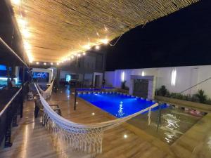 an indoor swimming pool with a hammock in a building at VILLA SARAMI in Villavicencio