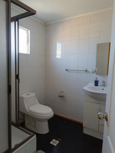 ein weißes Bad mit einem WC und einem Waschbecken in der Unterkunft HOSTAL EL VALLE in Angol
